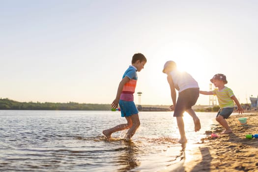 Cute kids having fun on the sandy beach in summer.