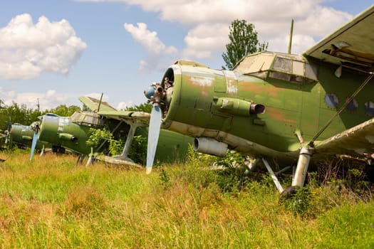 Old abandoned airfield with abandoned planes. Abandoned rusty old planes on the grass