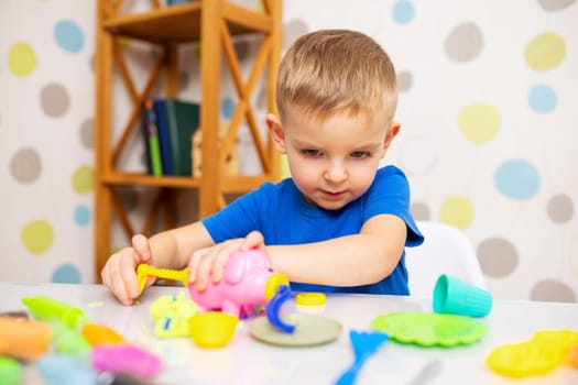 Kids playing with play dough. Cute children sitting at the table and plays with playdough. Creative leisure activity concept