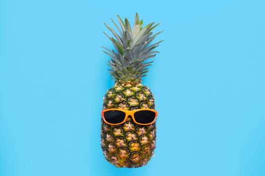 Pineapple with sunglasses on blue background.
