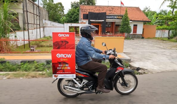 motorbike riding in asia as one of goods transportation method, being used to transport many kind of goods intercity in central java indonesia