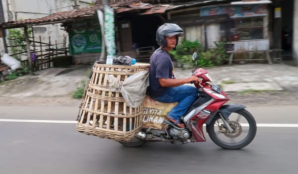 motorbike riding in asia as one of goods transportation method, being used to transport many kind of goods intercity in central java indonesia