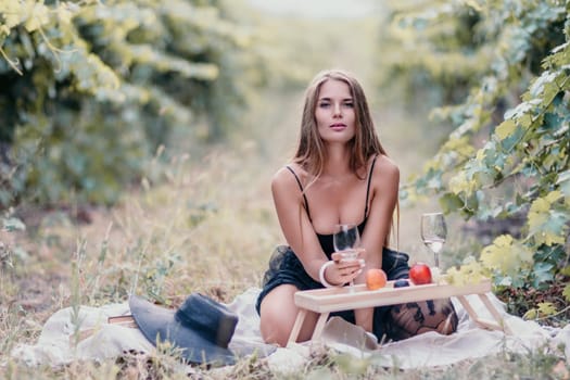 Picnic and wine tasting at sunset in the hills of Italy, Tuscany. Vineyards and open nature in the summer. Romantic dinner, fruit and wine.