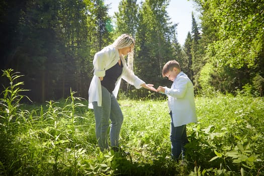 Young fat teenage boy playing with phone and mother swears, demands to stop it in a park. Blogger, gamer, streamer son online on Internet and conflict