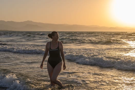 woman in a black swimsuit autumn on the Mediterranean sea 7