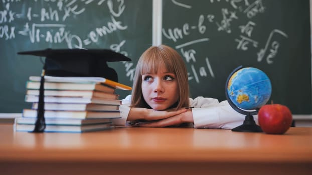 Blonde schoolgirl with bangs poses in front of school objects