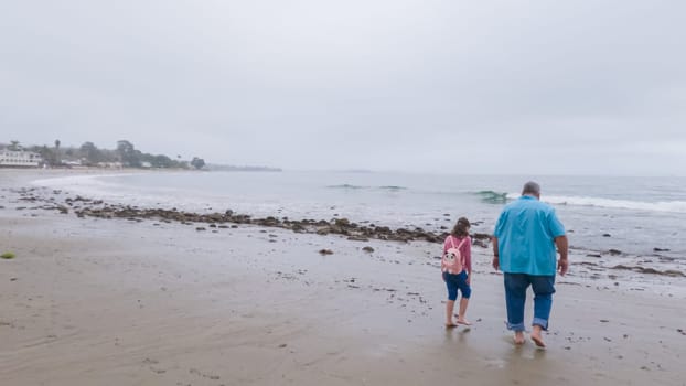 Walking along the shore of Miramar Beach, California, the overcast winter sky creates a tranquil and reflective atmosphere.