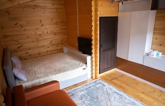 The cabins interior is paneled with wood and furnished with a bed, sofa, and armoire. A bearskin rug adds a touch of warmth to the space.
