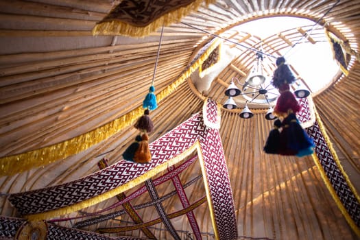 The inside of a yurt is adorned with vibrant fabrics and traditional decorations, creating a cozy and inviting atmosphere.