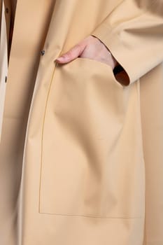 A model wearing an elegant beige coat with large front pockets. The coat is perfect for staying warm and stylish in the fall and winter.