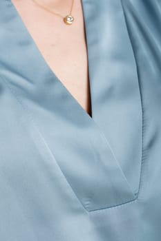 Closeup view of an elegant womans blouse with a stylish v-neckline, perfect for formal occasions. Fashion and style concept.