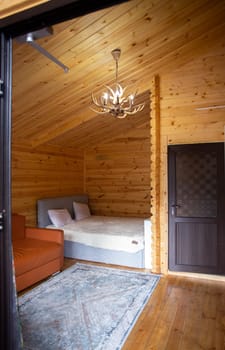 The cabins interior is paneled with wood and furnished with a bed, sofa, and armoire. A bearskin rug adds a touch of warmth to the space.