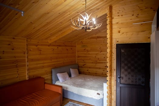 The cabins interior is paneled with wood and furnished with a bed, sofa, and armoire. A bearskin rug adds a touch of warmth to the space.