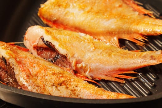 Fresh sea bass sizzles to perfection in a hot skillet, showcasing a delightful evening feast in the making.