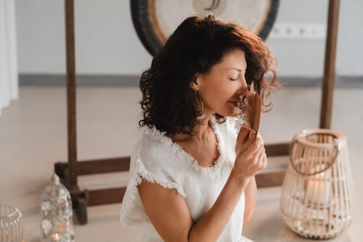 A woman in white clothes holds an envelope with a wish in her hands. The concept of a women's circle.