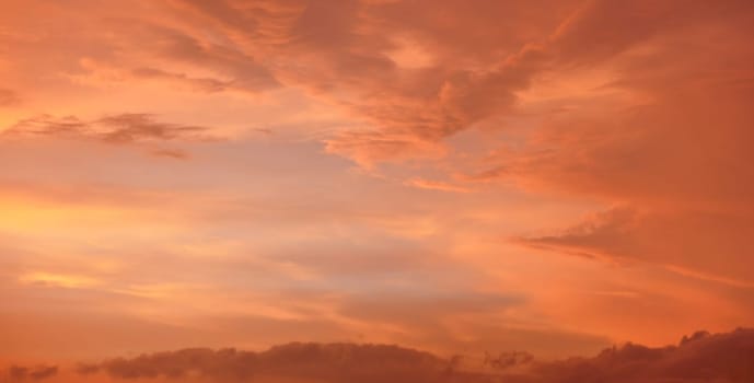 Orange and pink sky after sunset, silhouettes of mountains below - can be used as background with subjects placed in front