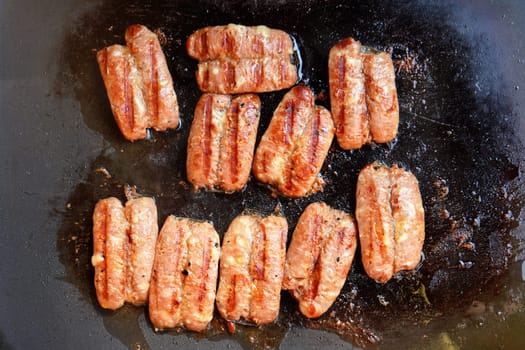 Small bratwurst / hot dog frankfurter sausages grilled on electric grill, view from above