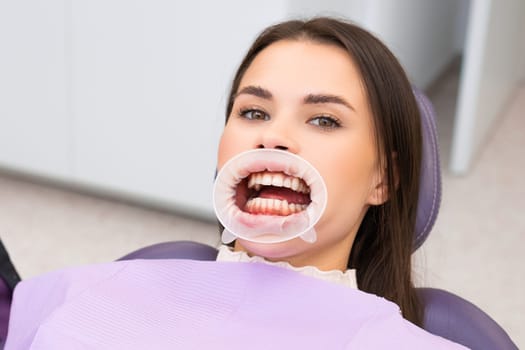 Portrait of a brunette patient in a dental chair.