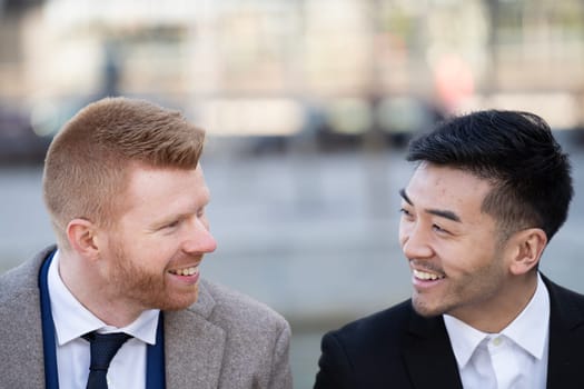 Close up portrait of two corporate executives smiling and discussing together outdoors.
