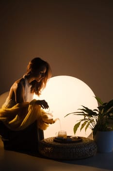 A young girl conducts an evening tea drinking procedure indoors. Relaxing tea party.