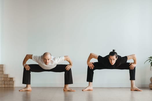 two young athletes practice yoga in the gym. Joint training, indoors, studio. The concept of a healthy lifestyle.