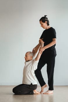 two young athletes practice yoga in the gym. Joint training, indoors, studio. The concept of a healthy lifestyle.