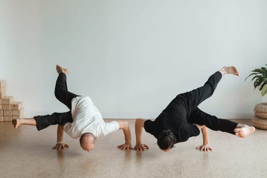 two young athletes practice yoga in the gym. Joint training, indoors, studio. The concept of a healthy lifestyle.