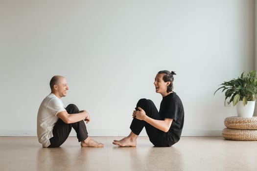 two young athletes practice yoga in the gym. Joint training, indoors, studio. The concept of a healthy lifestyle.