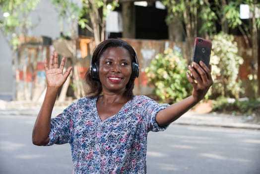 young woman standing outdoors looking at cell phone while smiling.portrait of a young woman with mobile phone.