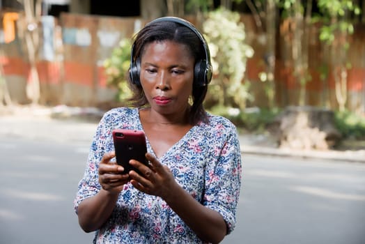 young woman standing outdoors looking at cell phone.