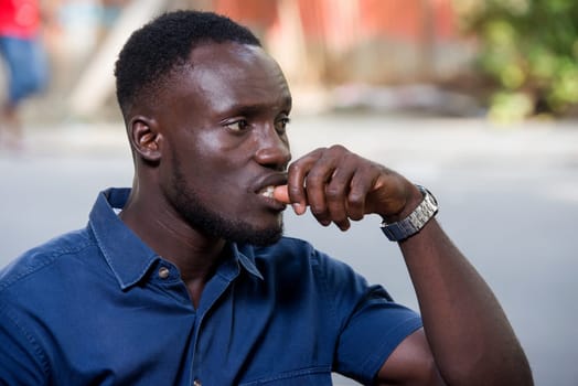 young man sitting outdoors thinking.