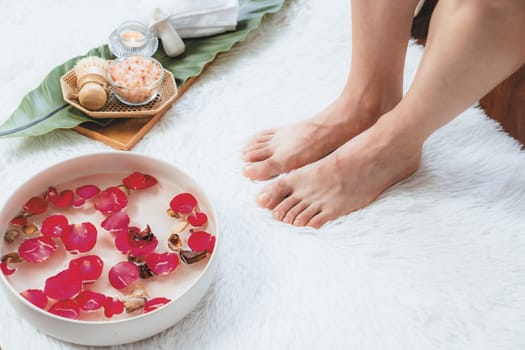 Woman indulges in blissful foot massage at luxurious spa salon while masseur give reflexology therapy in gentle day light ambiance resort or hotel foot spa. Quiescent