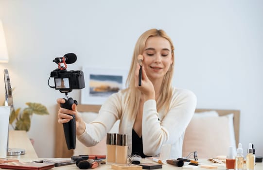 Young woman making beauty and cosmetic tutorial video content for social media. Beauty blogger smiles to camera while showing how to beauty care to audience or followers. Panorama Blithe