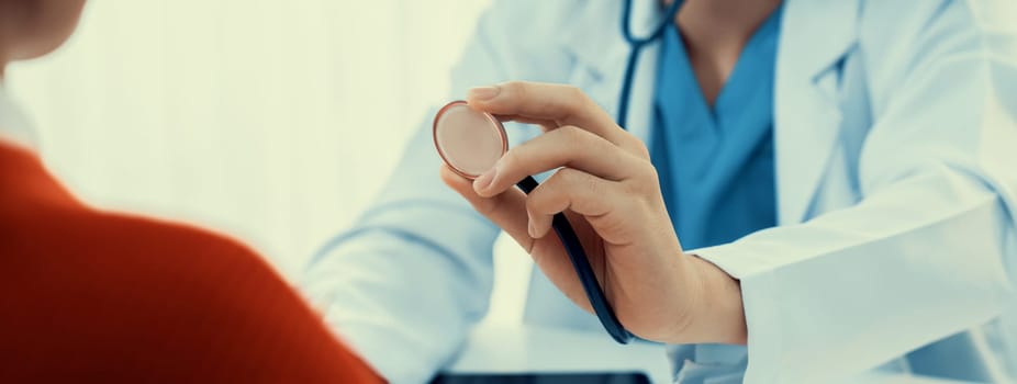 Patient attend doctor's appointment at clinic or hospital office. Doctor examining and diagnosis symptoms while checking the patient's pulse with stethoscope. Panorama Rigid