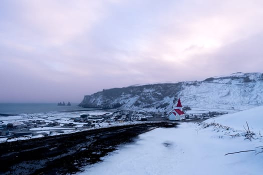 View of the Icelandic town of Vik after a snowfall at sunset