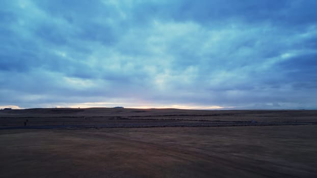 Large icelandic frozen fields in wintry weather, spectacular nordic landscape with snowy mountains and beautiful skies. Drone shot of candinavian scenery with nature, scenic route.