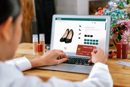 Woman shopping online on internet marketplace browsing for sale items for modern lifestyle and use credit card for online payment from wallet protected by uttermost cyber security software