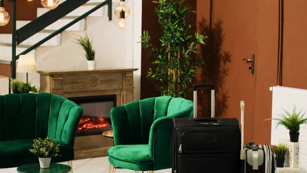 Modern empty lounge area with luggage and classy furniture, luxurious interior design in hotel lobby. Expensive rooms resort decorated with elegant lights and plants, trolley bags.