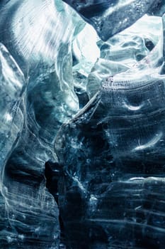 Inside of vatnajokull iceberg caves with cracked structure of ice blocks, icelandic nordic scenery. Huge transparent glacier in wintry freezing cold landscape, icy rocks in crevasse.