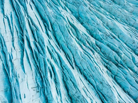 Aerial view of blue ice glaciers with crevasses, vatnajokull ice mass and glacier lagoon with freezing cold water in iceland. Diamond blue icy rocks surrounding scandinavian lake, climate change.