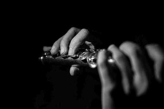 the hands of a musician on the flute - an wooden ancient musical instrument popular in classical brass marching jazz folk music, loved by children and adults, amateurs and professionals. High quality photo
