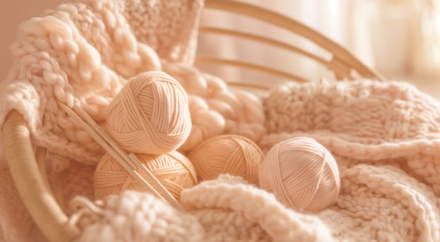 A basket of yarn balls and knitting needles with a soft knitted fabric in warm tones. High quality photo