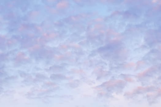 Background of blue sky with pale pink clouds in sunset