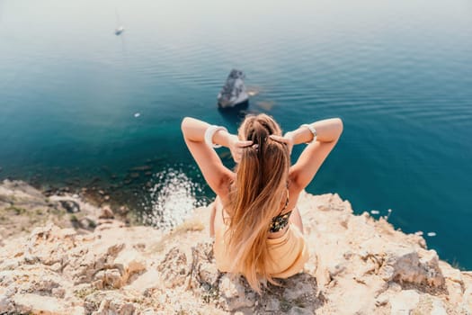 Woman travel sea. Happy tourist taking picture outdoors for memories. Woman traveler looks at the edge of the cliff on the sea bay of mountains, sharing travel adventure journey.