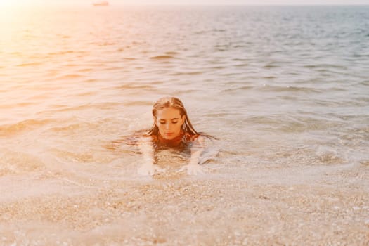 Woman travel sea. Young Happy woman in a long red dress posing on a beach near the sea on background of volcanic rocks, like in Iceland, sharing travel adventure journey