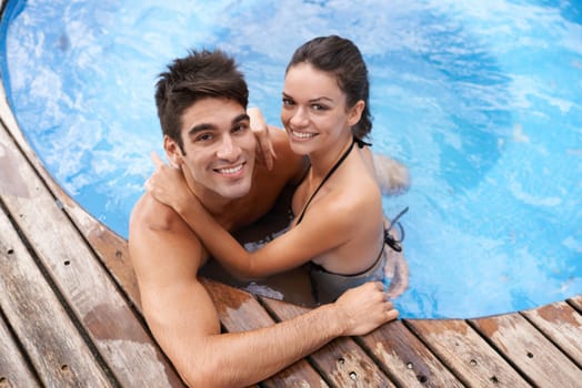 Couple, jacuzzi and smile on vacation for happiness, date and summer to relax outdoor. Aerial view, relationship and holiday with pool for affection, romance and bonding with support together