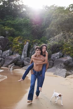 Beach, piggy back and couple with dog, travel adventure and relax on summer island holiday. Ocean vacation, woman and man happy in nature on romantic date together with smile, love and puppy in Bali.