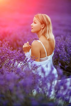 Woman lavender field. A middle-aged woman sits in a lavender field and enjoys aromatherapy. Aromatherapy concept, lavender oil, photo session in lavender.