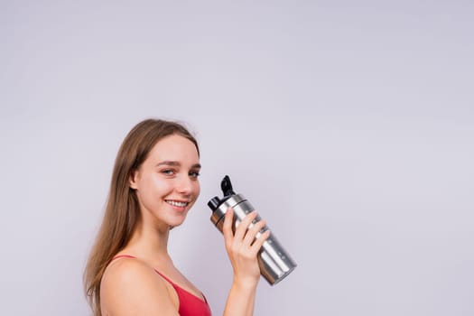 Image of beautiful strong happy cheerful young sport woman posing isolated indoors drinking water.