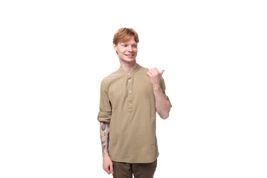 a young European man with red golden hair dressed in a light brown shirt gesticulates on a white background. advertising concept.